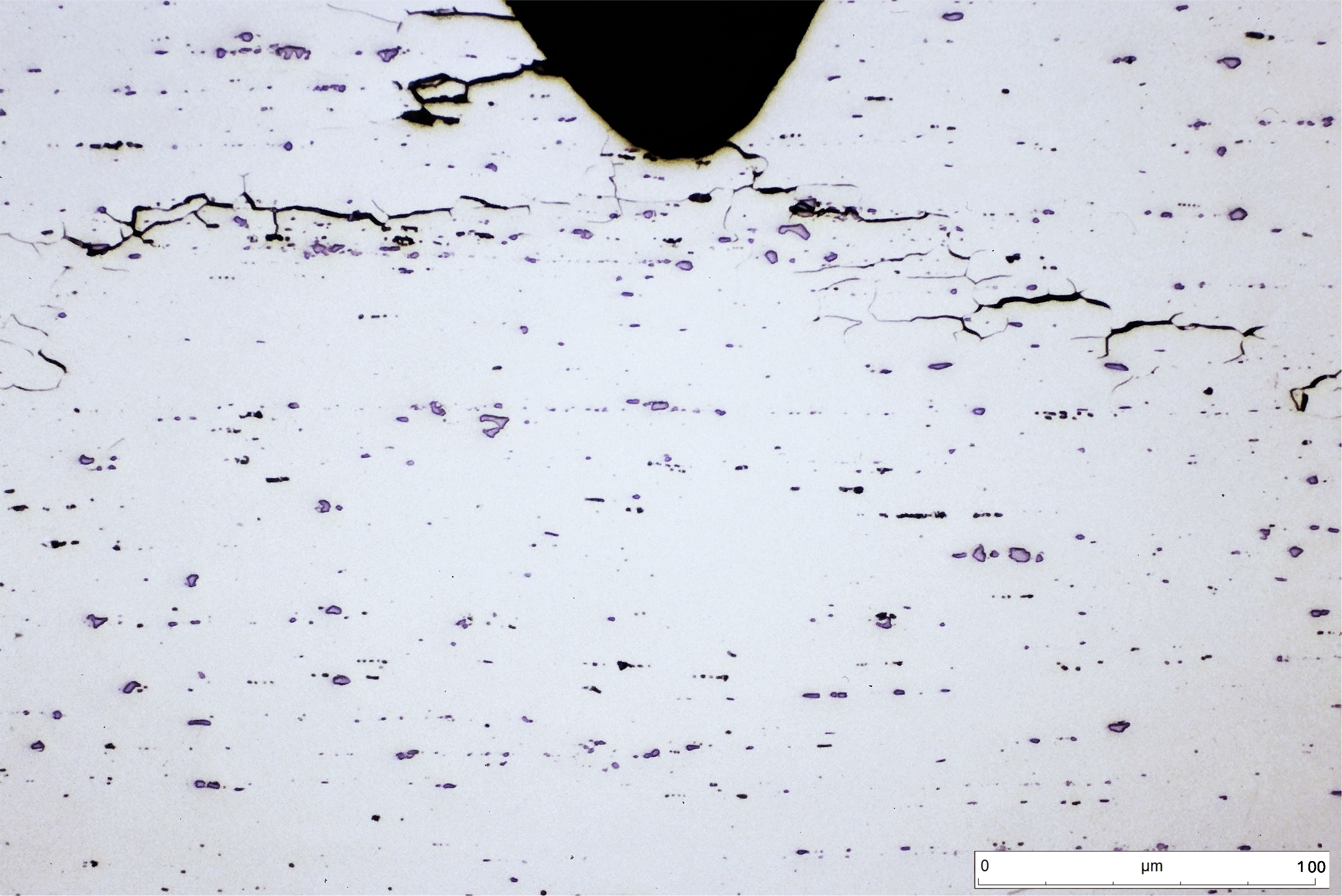Muestra a la que se le ha inducido corrosión bajo tensión en agua de mar. Ataque HF en agua. Se aprecia la grieta, pero no los límites de grano.