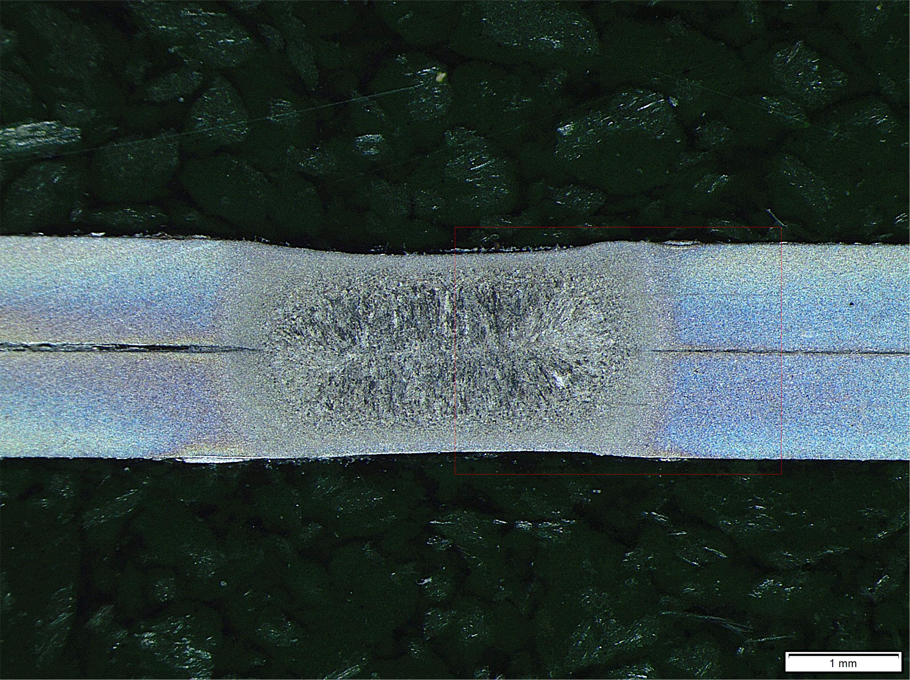 Macrografía de una unión por puntos de dos chapas de acero TRIP 690, mostrando la zona de fusión y las zonas afectadas térmicamente.